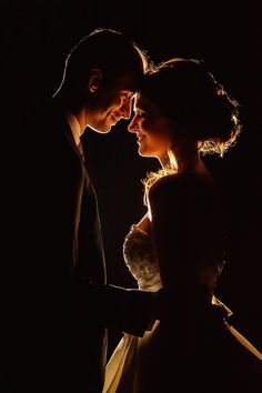 a man and woman standing next to each other in the dark