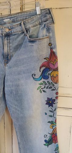 a pair of jeans with embroidered flowers on them