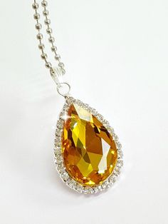 an orange and white diamond pendant on a chain