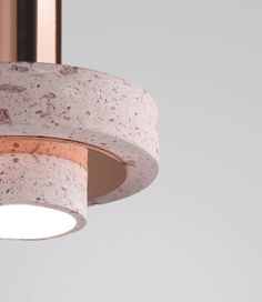 a close up of a light fixture on a white wall with a pink marble finish