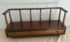 an old wooden box with four candles on it sitting on a cloth covered tablecloth