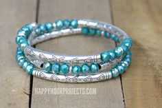 three wrap bracelets with turquoise beads and silver accents on a wooden surface, one has a fish charm in the middle