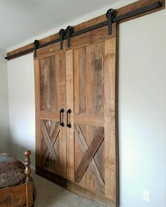 an image of a bedroom setting with sliding barn doors on the wall and bed in the background