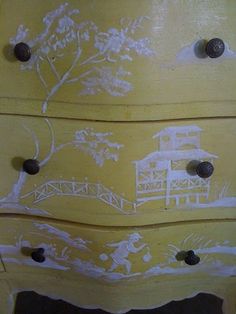 a yellow dresser with white designs on it