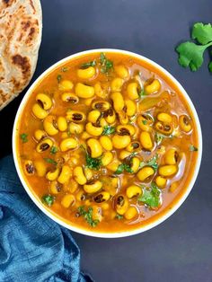 instant pot black eyed pea curry in a bowl with pita bread on the side