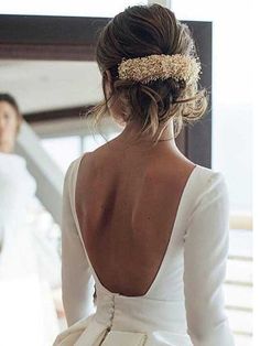 the back of a woman's dress with a gold head piece on her head