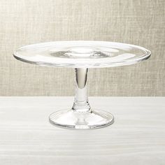 an empty glass cake plate on a white table