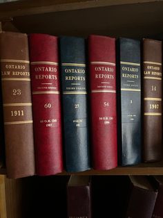 a row of law books sitting on top of a wooden shelf