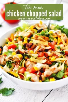 chicken chopped salad with lettuce and tomatoes in a white bowl on a wooden table