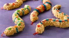 cookies with sprinkles and candy are on a purple surface, ready to be eaten