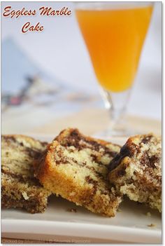 an eggless marble cake on a plate next to a glass of orange juice