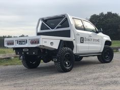 a white truck parked on top of a gravel road