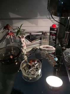 a glass table with various items on it and a lamp in the corner next to it