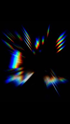 an abstract image with blurry lines in the middle and colors on the bottom, black background