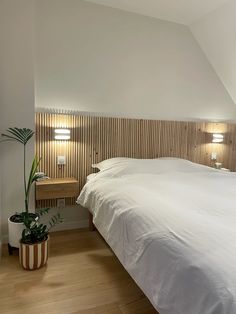 a large bed sitting under two lamps in a bedroom