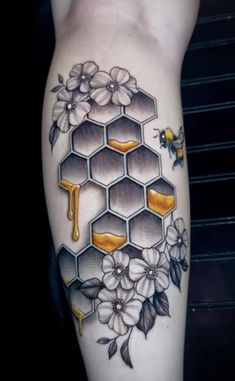 a tattoo with honeycombs and flowers on it