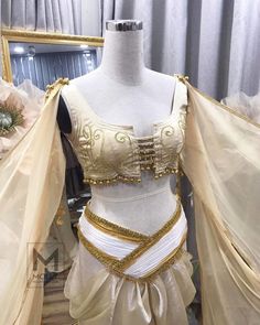 a mannequin dressed in white and gold clothing