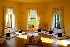 a room with many windows and yoga mats on the floor in front of two windows