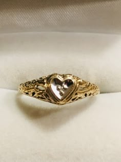 Very pretty vintage diamond heart ring. The diamond is set in a white gold heart while the ring is yellow gold. This a lovely delicate filagree setting in a size 6. Perfect condition. Professionally checked and polished. The diamond is small. You can see it in between the 3 prongs in the closeup. Heart Shaped Engagement Rings Vintage, Stamped 14k Heart Cut Diamond Ring For Wedding, Heart Cut Diamond Ring For Wedding 14k Stamped, Heart Cut 14k Stamped Wedding Diamond Ring, Heart Shaped Diamond Ring With Rose Cut For Promise, Heart Cut Ring With Rose Cut Diamonds, Heirloom Heart Promise Ring, Vintage Heart Cut Ring For Anniversary, Gold Heart Cut Rings With Rose Cut Diamonds