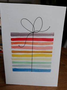 a card that has been drawn with colored lines and a bow on the top of it