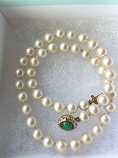 Step back in time with this elegant White Akoya Pearl Necklace, a Single Strand Pearl Necklace with a Jade Cabochon closure, a timeless piece of jewelry from the 1940s  that exudes classic sophistication and grace. This beautiful single strand necklace features lustrous cabochon pearls, each carefully selected for their radiant glow and smooth texture. Adding a touch of unique charm, the necklace is accented with a striking green jade cabochon, creating a captivating contrast that enhances the o Luxury Vintage Akoya Pearl Jewelry, Antique Pearl Necklace For Formal Occasions, Vintage Single Strand Jewelry For Formal Occasions, Vintage Yellow Gold Single Strand Necklace, Antique Jewelry For Vintage Events, Elegant Vintage Charm Bracelets For Anniversary, Antique Round Jewelry For Formal Occasions, Elegant Vintage Charm Bracelet For Anniversary, Collectible Classic Jewelry With Vintage Charm