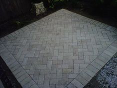 an outdoor area with a brick walkway and potted plant