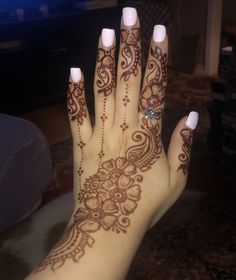 a woman's hand with henna tattoos on it