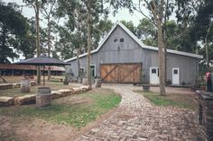 a barn with a brick walkway leading to it