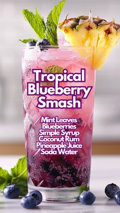 a blueberry smoothie in a tall glass with ice and mint garnish