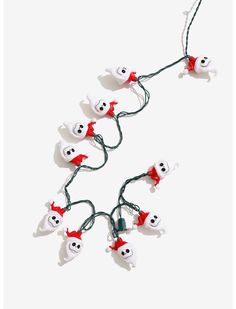 halloween ghost string lights with red bows and white heads are hanging from green cords on a white background