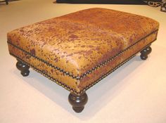 a brown ottoman sitting on top of a white floor