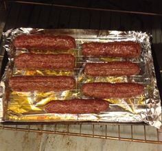 hot dogs are cooking on tin foil in the oven, ready to be cooked and baked