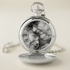 a silver pocket watch with roman numerals on the face