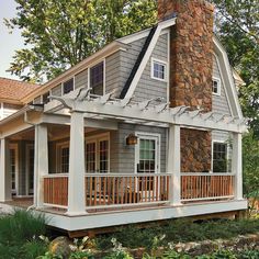 a small house with a porch and stone chimney