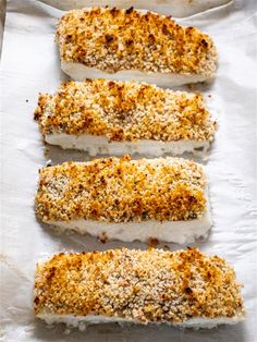 four pieces of fish are sitting on wax paper and ready to be cooked in the oven