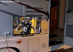 a flat screen tv mounted to the side of a white truck with a football player on it