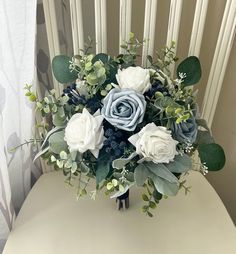 a bouquet of blue and white flowers on a chair