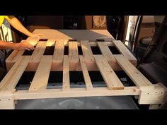 a person sitting in the back of a truck with wooden boards on it's bed