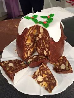 a cake with white frosting and christmas decorations on the top is cut into pieces