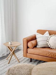 a brown leather couch sitting next to a table