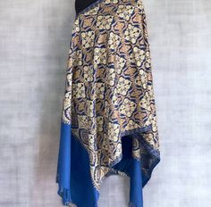 The fashionable pashmina shawl is handmade, a harmonious masterpiece combining beauty and practicality. This stunning shawl, carefully sewn, has a bright blue hue, radiating heat. The shawl is decorated with a charming floral pattern adorning the entire space of the shawl. Exquisite embroidery, decorated with rich shades of gold and bronze colors, gives elegance to the design of nature. This unique scarf is thoughtfully designed to seamlessly transform into a traditional hijab, wear it as a hijab or as a cape. Made of high quality light materials, the Hijab convertible is ideal for cool weather, offering you a cozy layer of heat while maintaining breathable. The soft touch of the fabric ensures that you will be comfortable throughout the day, regardless of the season. Designed for versatil Traditional Blue Hijab For Eid, Elegant Zari Work Shawl Scarves, Elegant Motif Scarves For Festive Occasions, Bohemian Pashmina Shawl With Pallu, Pashmina Shawl Scarf With Pallu, Elegant Scarves With Motifs For Festive Occasions, Elegant Festive Scarves With Motifs, Festive Silk Shawl Scarf, Elegant Blue Pashmina Shawl For Festivals