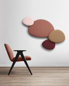 a chair sitting in front of a table on top of a hard wood floor next to a white wall