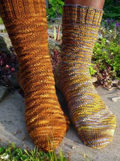 the legs of a person wearing socks made out of knitted yarn in front of some plants