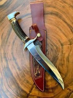 a knife and sheath sitting on top of a wooden table