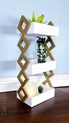 three tiered planter with succulents and candles on the bottom shelf