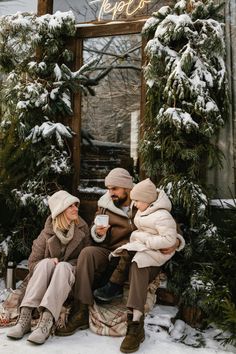 a man and two women sitting on a bench in the snow