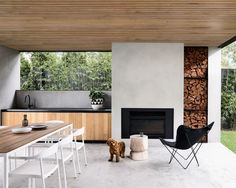 a dog standing in the middle of a room next to a table with chairs and a fire place