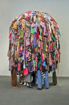 three people standing in front of a large pile of ties