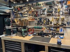 a workbench with many tools hanging on the wall