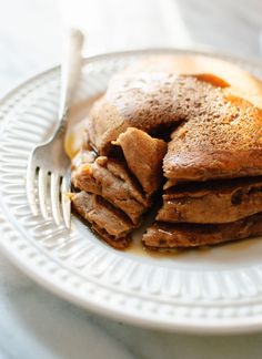 a white plate topped with pancakes covered in syrup